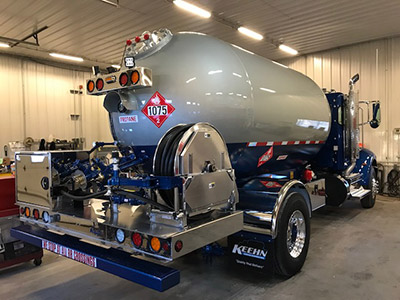 A propane bobtail truck is parked in a garage.